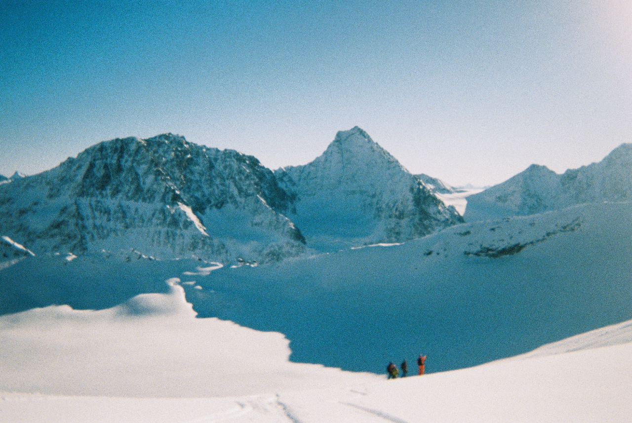 Trois alpinistes au pied de sommets enneigés